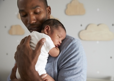 Young Father with Newborn Baby in Arms